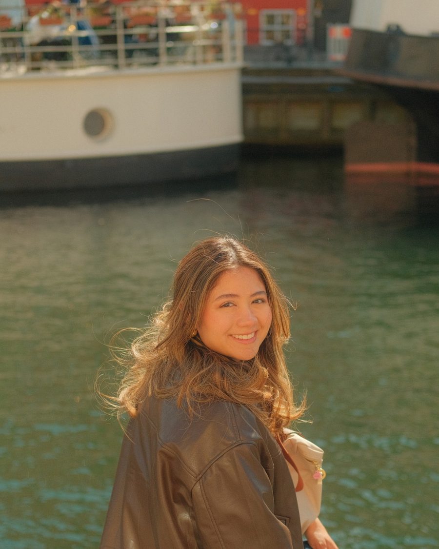 Maria Largaespada smiling over her shoulder by a canal, with a boat behind her